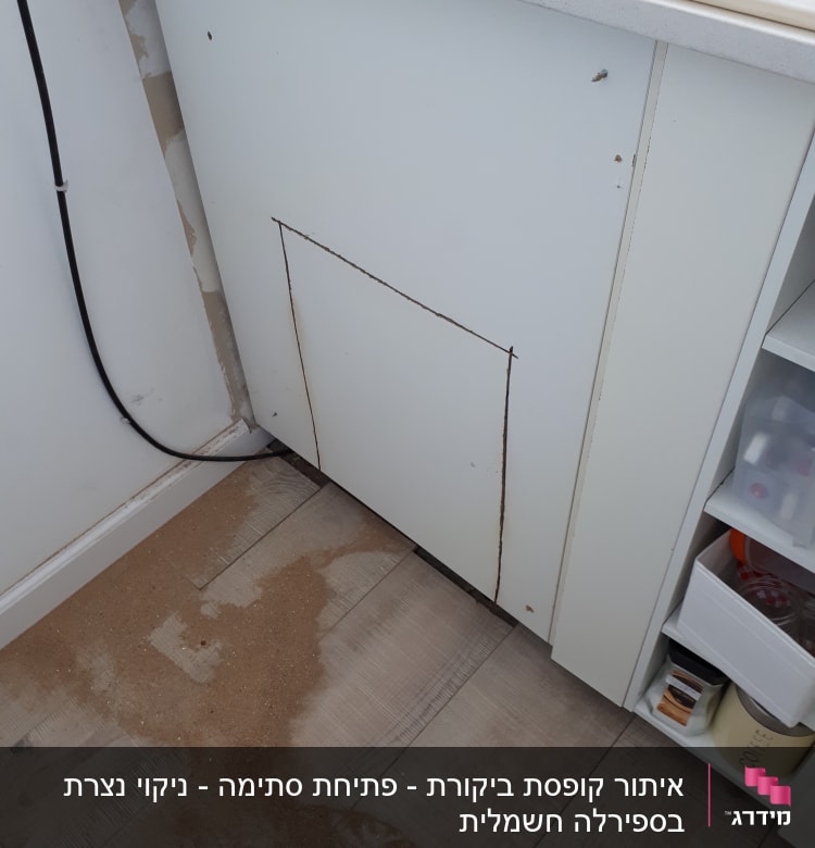 ארון מטבח עם סימני ניסור ונסורת על הרצפה
